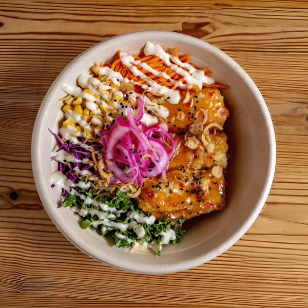 Bao by Kaya's Asian-fusion bowl with crispy chicken, pickled onions, corn, carrots, and greens.