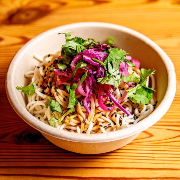 Bao by Kaya's Asian-fusion noodles with red cabbage, cilantro, and black sesame seeds in a bowl.